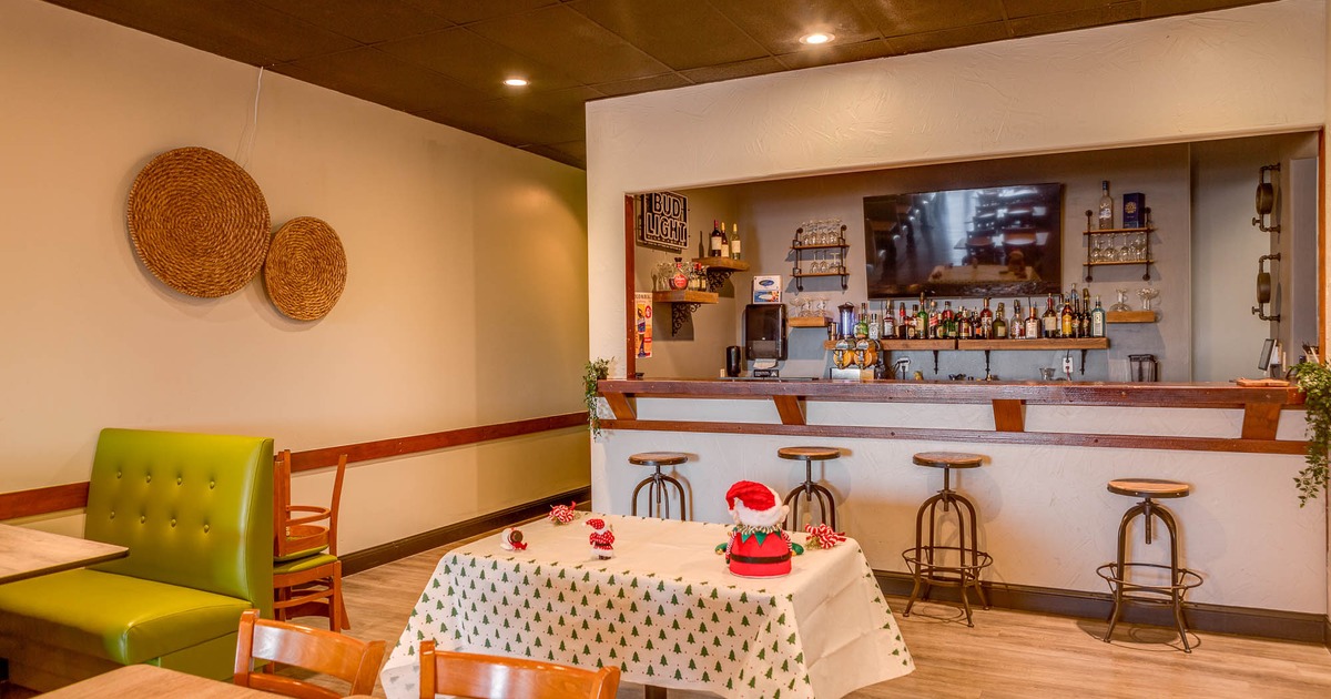 Interior, tables and chairs with bar in the back