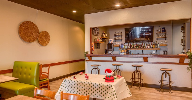 Interior, tables and chairs with bar in the back