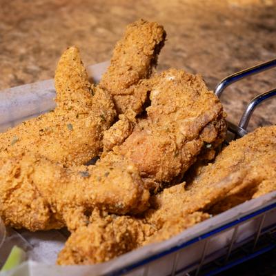 Crispy fried catfish in a paper lined basket.
