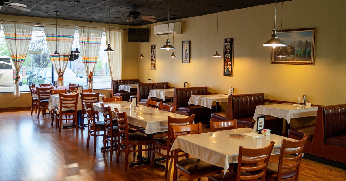 Cozy restaurant interior with wooden tables and chairs, and brown leather booths