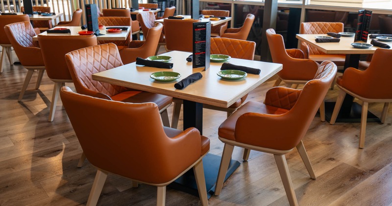 Interior, dining area, wooden top tables with leather padded chairs, ready for guests
