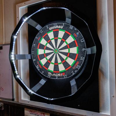 A professional dartboard with integrated LED lighting inside the venue.