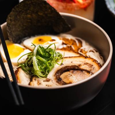 Ramen with braised pork belly, soft-boiled eggs, and green onions.