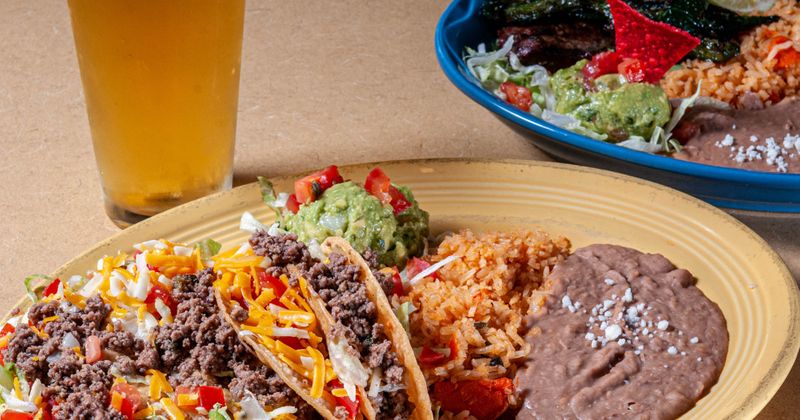 Aidan's Crunchy Tacos plate and a glass of beer