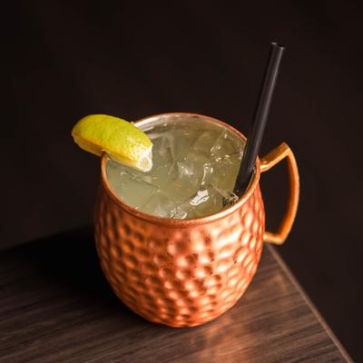 Pigeon Lake Mule in a copper mug with lime wedge and black straw.