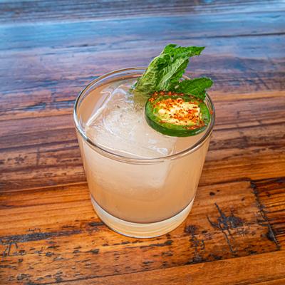 Spicy Margarita garnished with a jalapeño slice and mint leaves.