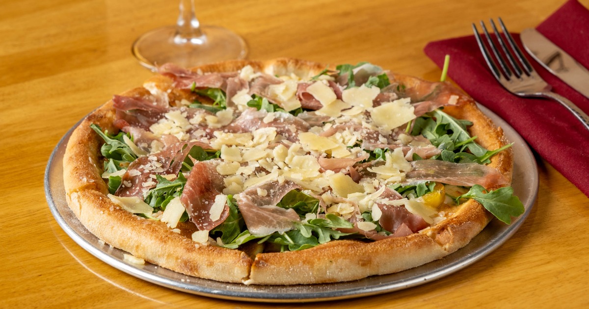 Prosciutto and arugula pizza with shaved Parmesan cheese