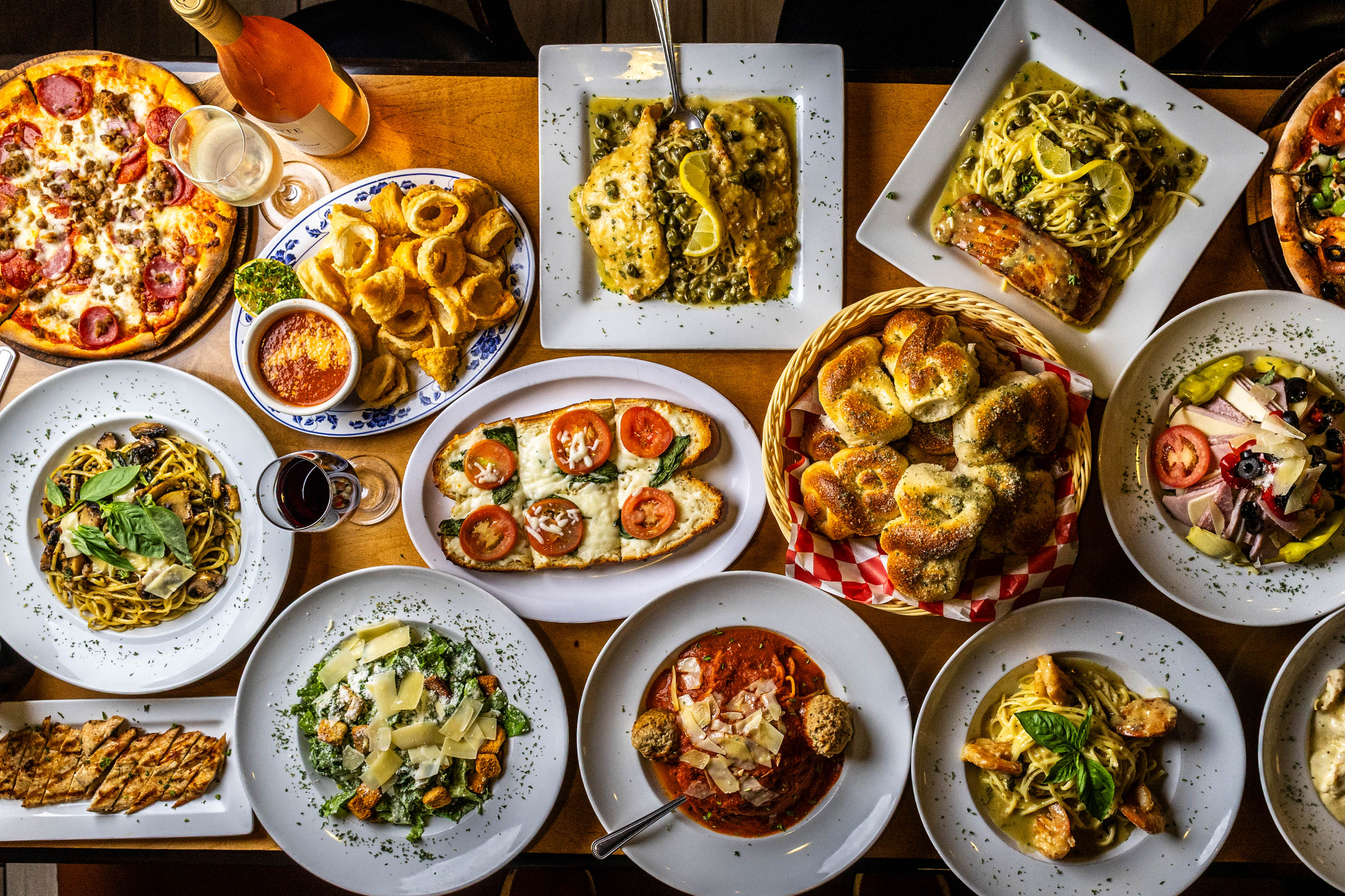 Top-down view of assorted Italian dishes on a wooden table