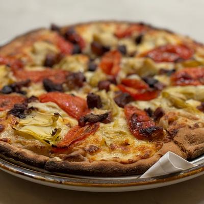 Pancetta & Artichoke pizza, house-made garlic Alfredo, tomato confit, micro fennel.