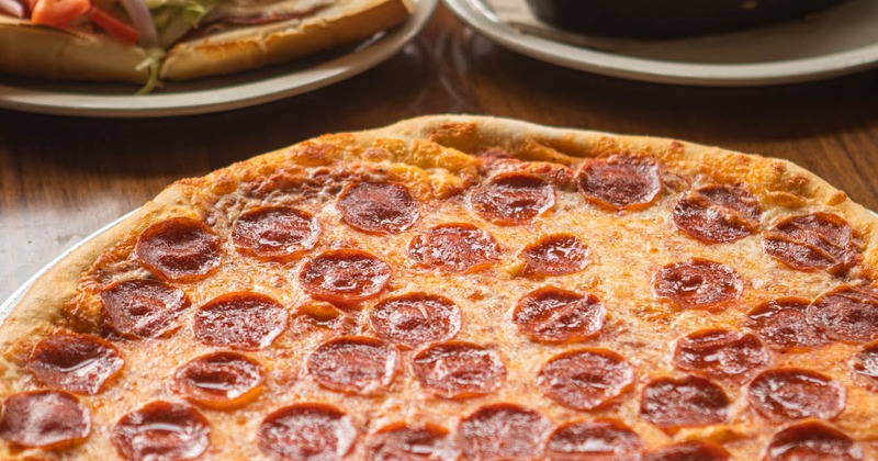 Pepperoni pizza, served with various other dishes