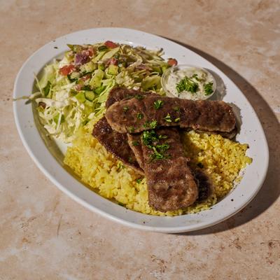 Lamb gyro meat, served with salad, rice, and butter.
