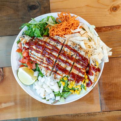 BBQ chicken salad with lettuce, corn, carrots, and tomatoes.
