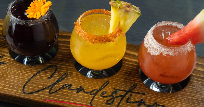 Cocktails on wooden plate with name of restaurant