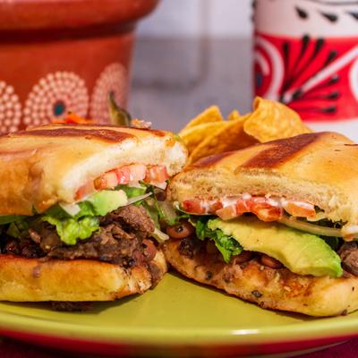 Grilled steak sandwich, with mayo, pinto beans, tomato, and avocado.