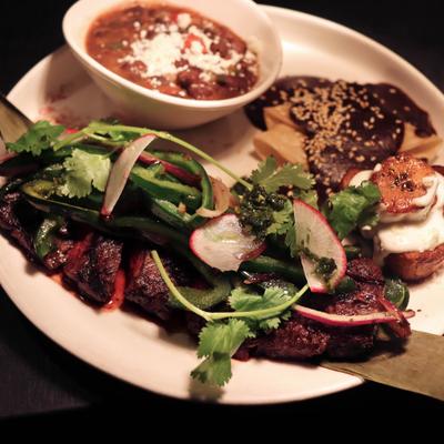 Grilled skirt steak with enchilada de mole and charro beans.