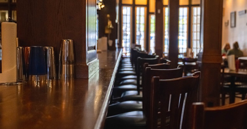 A bar, chairs in the line, entrance