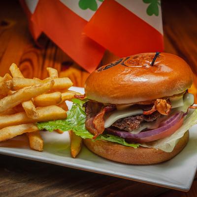 Bacon cheeseburger, with lettuce, tomato, onion, and a side of fries.