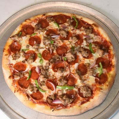 Pepperoni and sausage pizza topped with red onions and green peppers.