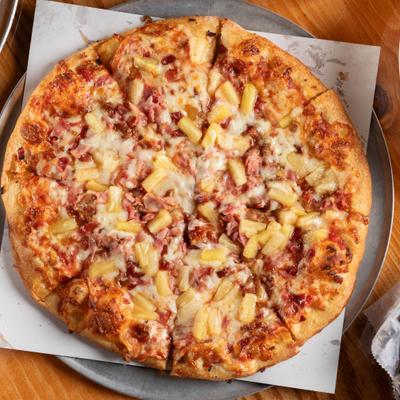 Hawaiian pizza topped with melted cheese, ham, and pineapple.
