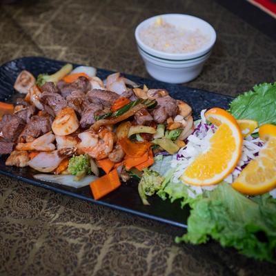 Steak and shrimp plate and a bowl of rice.