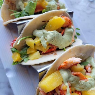 Lobster tacos topped with pineapple salsa and avocado aioli.