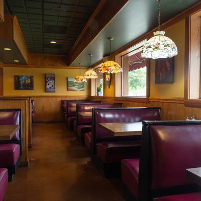 Interior with booth saeating, framed art on the walls and decorative pendant lamps.