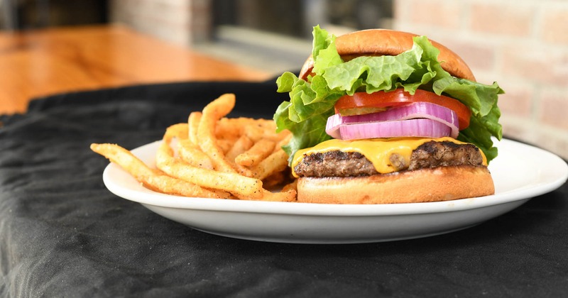 Cheeseburger with lettuce, tomato, and onions, served with fries