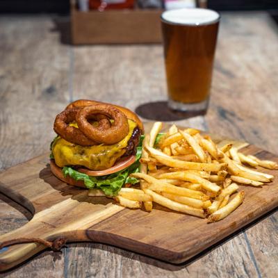 Cheeseburger, with tomato, lettuce, onion rings, fries and a glass of beer