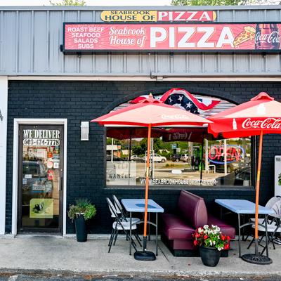 Exterior, sidewalk, table, chairs, parasols.