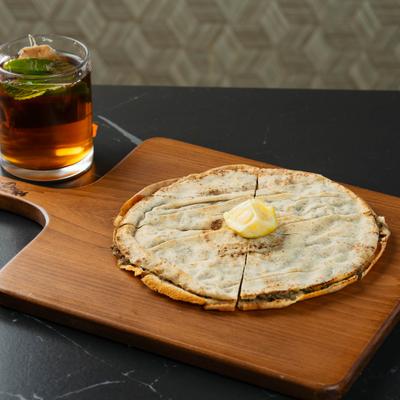 Meat-stuffed flatbread served with herbal tea.