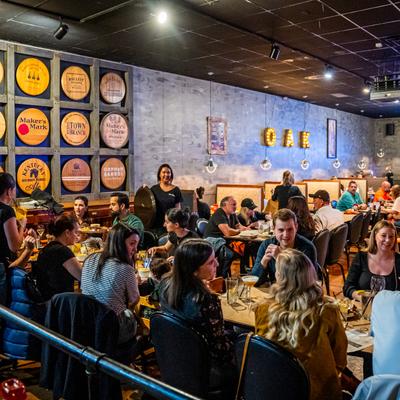 Dining area filled with people sitting at tables and wait staff moving around.