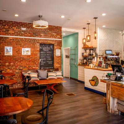 Interior, seating area, round tables with chairs, checkout counter on the right.