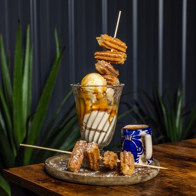 Cinnamon churros served on vanilla ice cream topped with cajeta and affogato.