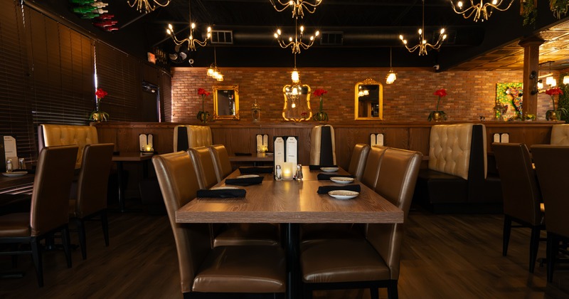 Interior, dining space with wooden tables, leather chairs and leather benches, chandeliers and golden frame mirrors