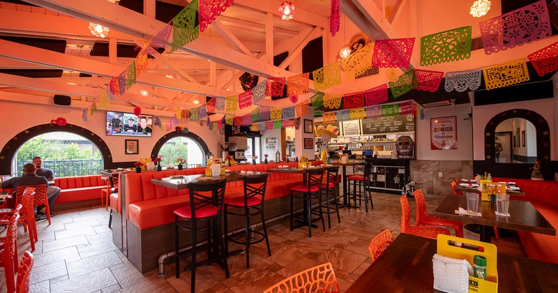 Lively Mexican-style interior dining area decorated with hanging paper ornaments