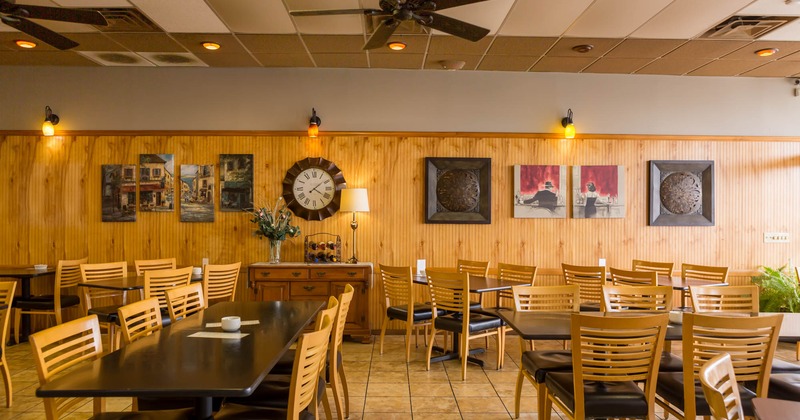 Inside, long dining tables with chairs, wood panels, decoration