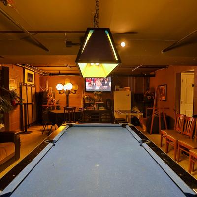 Living room with a pool table in the middle.