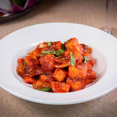 Plate of Chili Paneer topped with fresh herbs.