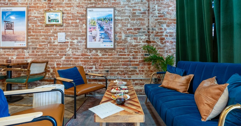 Interior, lounge area, three seater sofa with armchairs and coffee table, brick walls