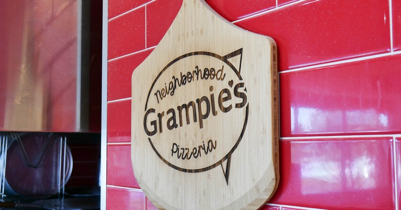 Interior, wooden peel  sign on a wall with carved restaurant's trademark