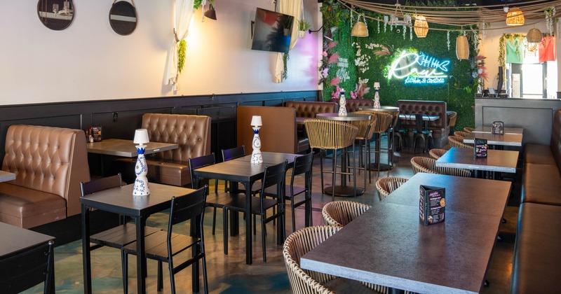 The interior of a modern restaurant with various seating, and hanging lights