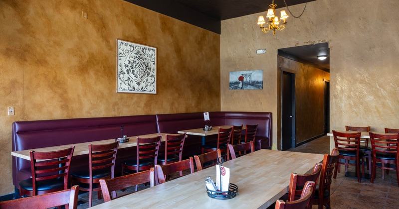 Cozy restaurant interior with warm beige walls, red cushioned booth seating