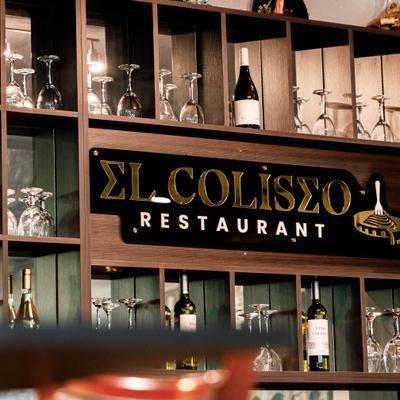 Restaurant's shelving display featuring branded wine bottles, glassware and signage.