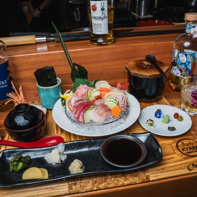 Sashimi platter served with various sides, condiments and bottles of Japanese spirits.
