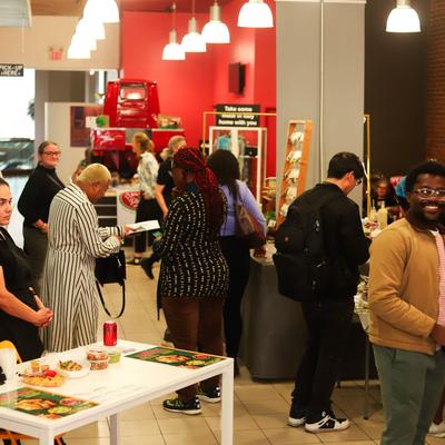 People standing around at an event in the restaurant.