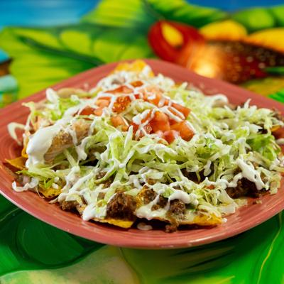 Ground beef and chicken nachos, topped with lettuce, sour cream and tomatoes.