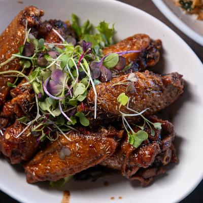 Glazed chicken wings topped with microgreens.