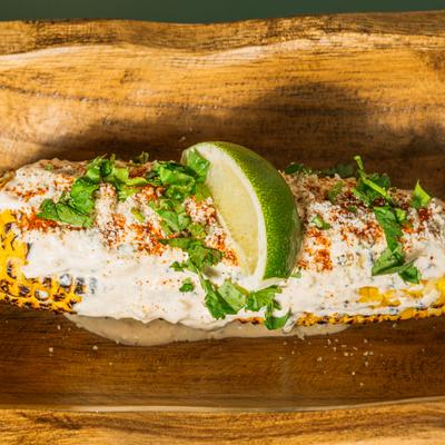 Mexican street corn topped with cheese, crema, and cilantro.