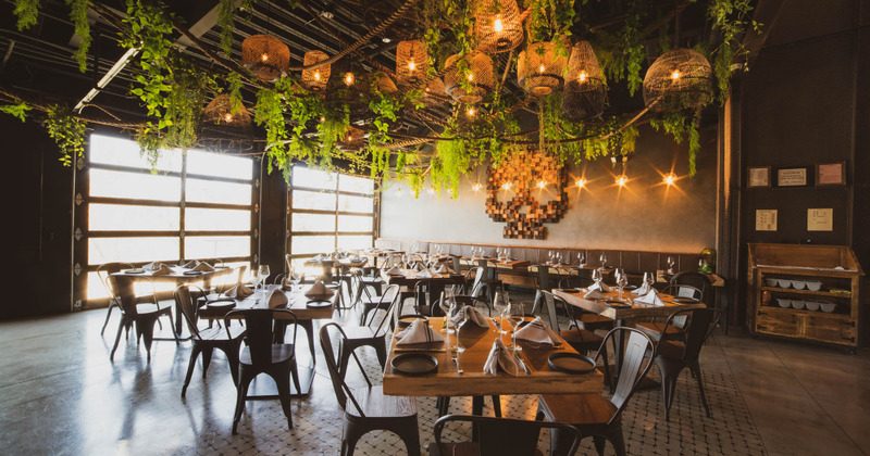 Restaurant interior - tables ready for guests, elegant lighting, green ornaments above