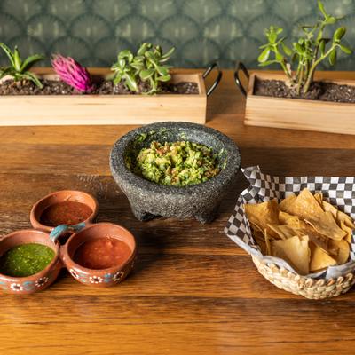 Tortilla chips, guacamole, and salsa sauces.